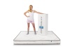 Model Standing On Mattress with compressed and rolled mattress in a box next to her