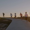 people running on a trail during sunset